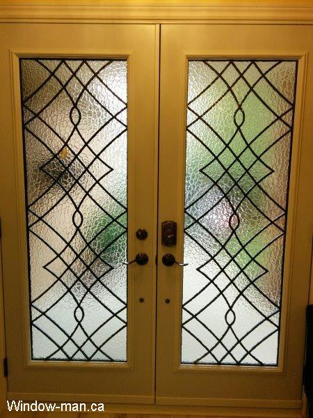 Double front entry steel insulated exterior doors. Brown. Oak Ridge wrought iron glass inserts. This is Pic 1041 view from inside